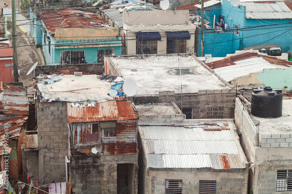 Naklejka premium Rusty old roofs of a poor residential district of Santo Domingo, aerial urban view of Dominican Republic
