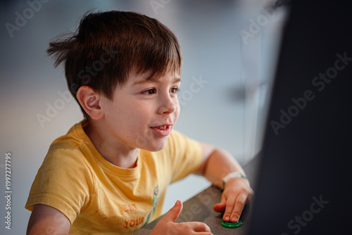 Young boy looking at interactive touchscreen exhibit in science museum, educational technology engagement