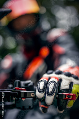 Close-up of a motorcyclist’s gloved hand gripping the brake or clutch lever, featuring protective sport riding gloves with reinforced knuckles and enhanced grip. The image highlights control, safety