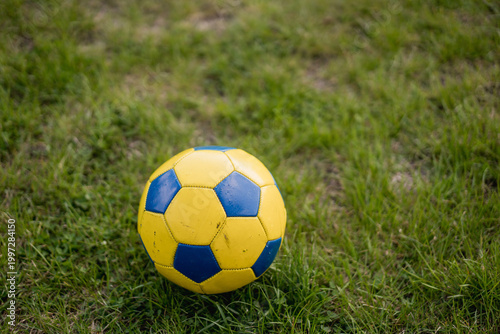 Blue and yellow soccer ball on grass
