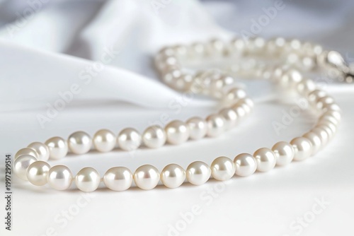 Elegant Pearl Necklace Resting on White Fabric With Soft Light Shining Through