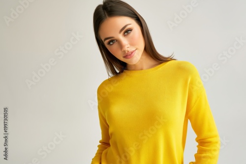 Woman in Yellow Sweater Smiling Against a Light Background During a Photoshoot