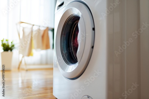 Washing Machine in Home Setting With Clothes Drying on a Rack Nearby in Brigh...