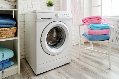 Washer and Bathtub in Bright Bathroom With Natural Light and Clean Clothes Dr...