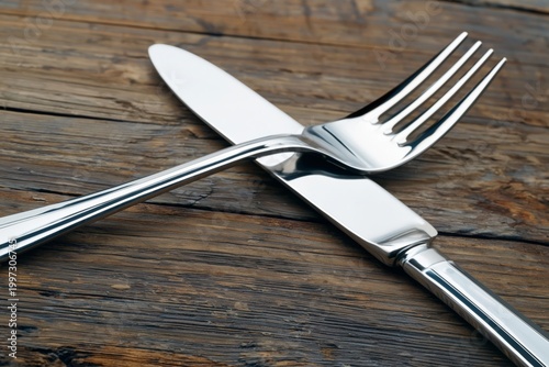 Close up of Fork and Knife Resting on Wooden Table at a Dining Setting