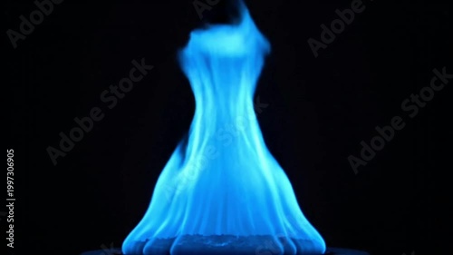 Vibrant blue flame against a dark background with warm glow