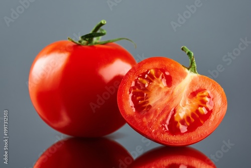 Fresh Red Tomatoes Cut in Half on a Gray Background Showcasing Seeds and Fles...