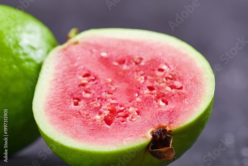 Fresh Guava Sliced Open on Dark Background Showing Pink Flesh and Seeds