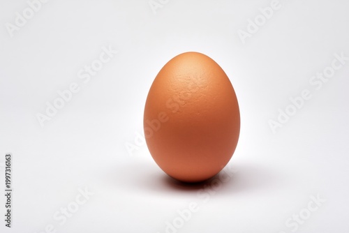Fresh Egg Sits on a White Surface Ready for Cooking or Baking at Any Time of Day