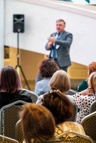 Картината върху платно Business speaker addresses attentive seated audience during professional conference presentation, networking and discussion