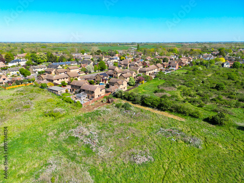 Interesting drone UAV view of the corner of an established British housing estate in the east of England. The scrubland is home to many aspects of nature and is on former agricultural land.