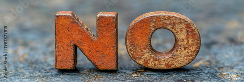 Close-up macro photograph of weathered, rustic wooden letters spelling out 'NO' against textured, out-of-focus background, symbolizing rejection and refusal.