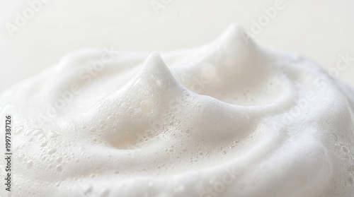 Gently sculpted white foam rises gracefully with delicate peaks, revealing a cloud like texture, evoking a sense of pristine purity and airy lightness