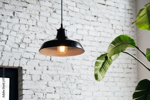 Unique Black Pendant Light Hangs From Ceiling in Modern Room With White Brick...