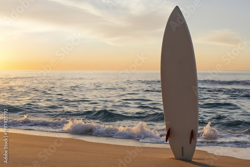 Surfboard Stands on Beach During Sunset With Waves Rolling In