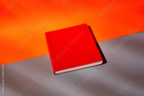 Notebook Placed on Orange Surface With Dark Gray Background in Well-Lit Setting