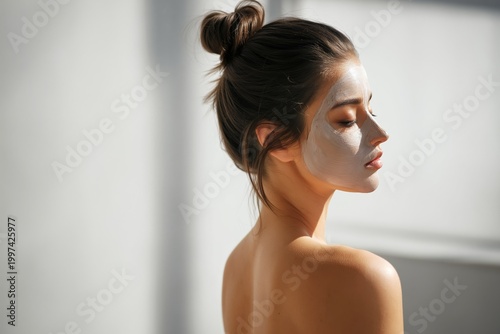 Woman Applying Facial Mask in Bright Indoor Setting Near Large Window
