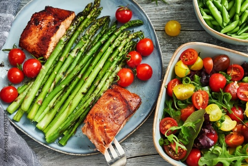 Fresh Grilled Salmon With Asparagus, Tomatoes, and a Salad on a Wooden Table ...
