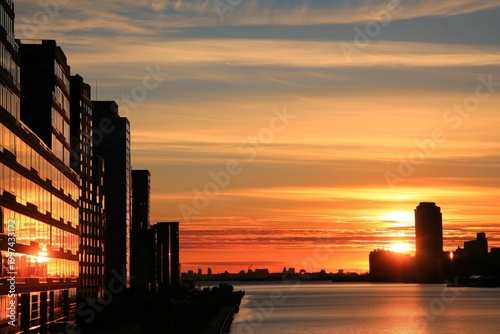 Beautiful Sunset Over a River With Buildings Along the Shore at Dusk