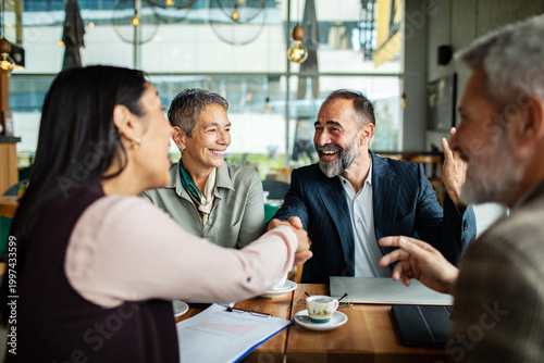 Business colleagues sealing a deal in a cafe