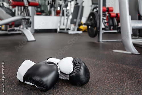 Boxing Gloves on Gym Floor in Training Area With Punching Bags in Background