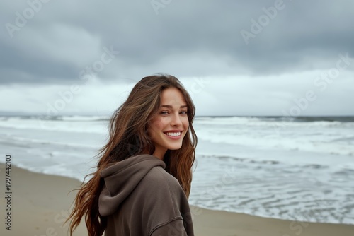 Woman Smiles at the Beach as Waves Crash Under Gray Clouds During Afternoon
