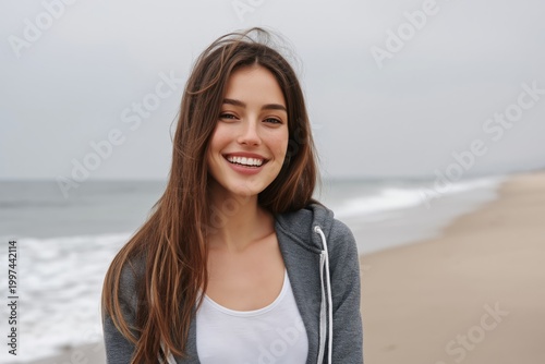 Woman Smiles at the Beach as Waves Crash Under Gray Clouds During Afternoon
