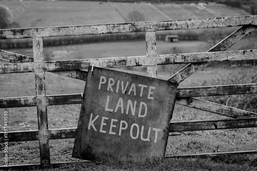 Private land keep out sign on farm gate black and white