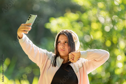 Young woman taking a selfie video with smartphone outdoors