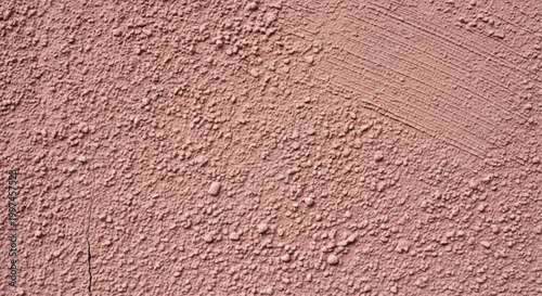 Textured surface with pinkish-brown granules and subtle cracks