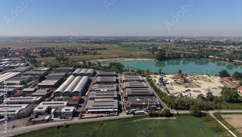 Foto Industrial Landscape Under the Sky: A vast industrial complex sprawls across the foreground, with factories and warehouses