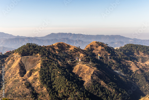 Cuadro en lienzo lush green hills and pine forest valley with small village scenic mountain lands