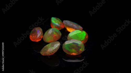 Polished Fire Opals with Vibrant Orange and Green Play of Color on Black Background, Macro Jewelry Shot