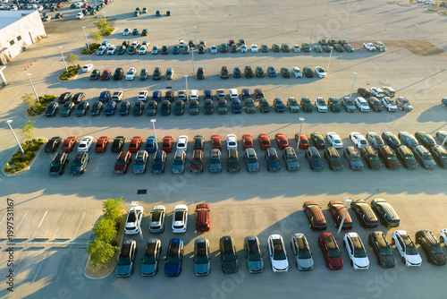 Aerial view of dealership parking lot with many brand new cars for sale. Development of american automotive industry concept
