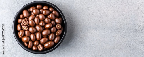 Top-down Black bowl of glossy chocolate-covered coffee beans on grey texture with ample copy space. Indulgent sweet snack concept., Coffee ,Snack