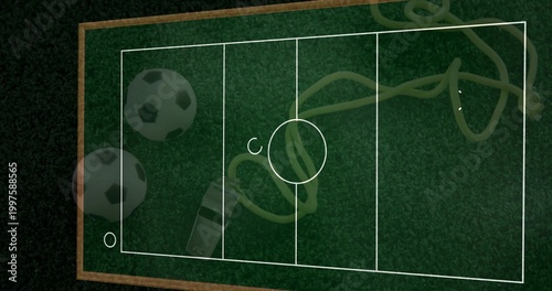 Displaying green turf board with pitch lines on table, soccer balls, whistle, yellow cord, markers