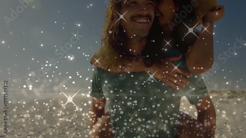 Woman climbing onto man back man carrying her travel beach glitter covering placing hat nuzzling