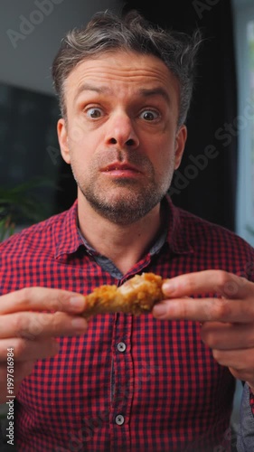Junk food advertisement concept. Man eating fried chicken, enjoying fast food.