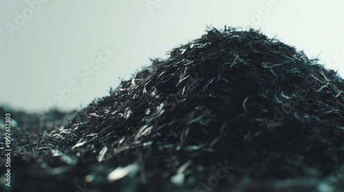 Dark textured pile of soil and compost with fragmented fibrous particles and charcoal rich residue forming an abstract close up background evoking earth, recycling, and growth