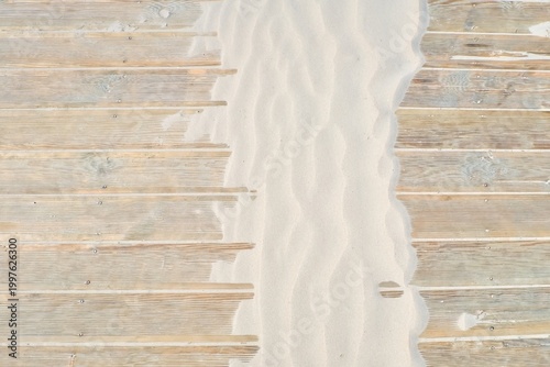 фотографія Top view of wooden boardwalk partially covered by windblown sand ripples