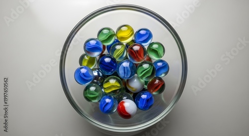 Vibrant Glass Marbles in Clear Bowl - Top View of Childhood Game Toys