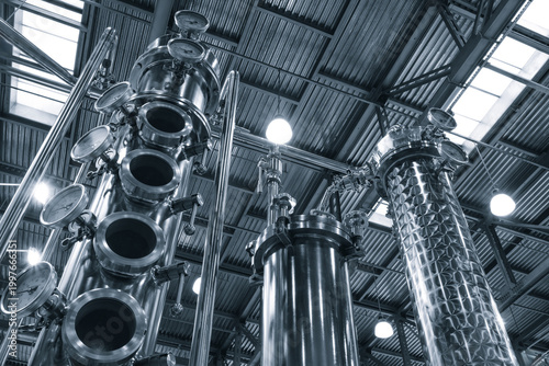 Photos interior of an industrial distillery features tall copper and stainless steel columns