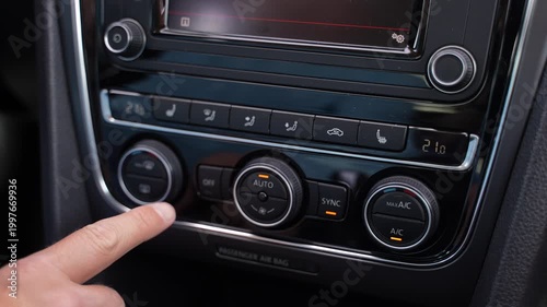 Hand pressing car climate control button slow motion