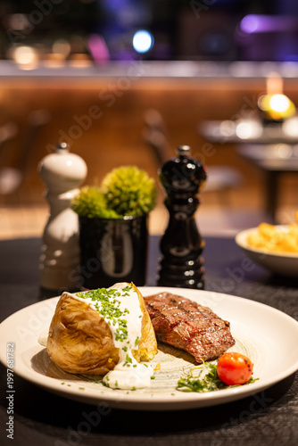 Juicy cheeseburger on plate with mustard and ketchup dips on the side, served in a cozy restaurant environment with warm lighting and shallow depth of field.