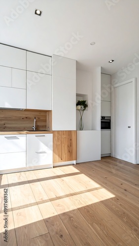 Modern kitchen with white cabinets, wood accents, and light oak flooring. Bright, minimalist space with an oven