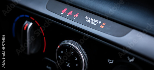 Close up view focusing on the rotary analog climate control temperature knobs and air conditioning dials located on the center console of a modern interior