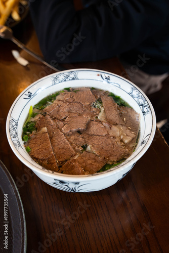 generous bowl of traditional Vietnamese Beef Pho served in a blue-and-white patterned ceramic bowl