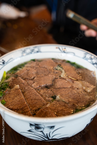 generous bowl of traditional Vietnamese Beef Pho served in a blue-and-white patterned ceramic bowl