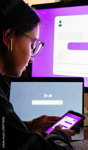 Young woman writing AI promt in a modern office.