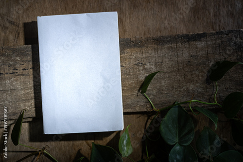 Blank White Card Mockup on Wooden Table with Green Foliage, Minimal Natural Flat Lay
